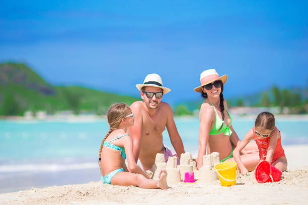 istock Family making sand castle at tropical white beach 958848536