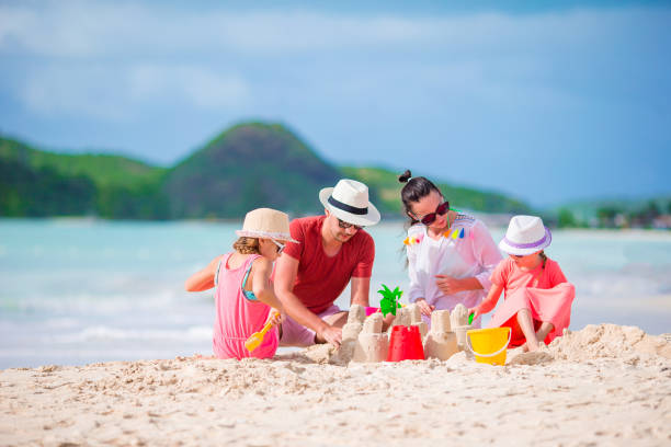 istock Family making sand castle at tropical white beach 958849254