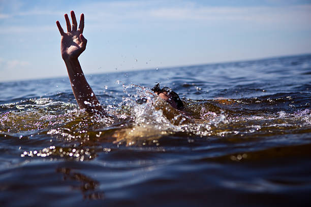 Person drowning in water with hand reached out  Seeking rescue. drowning photos stock pictures, royalty-free photos & images