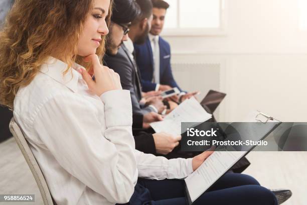 Group Of Business People Sitting On Chairs Stock Photo - Download Image Now - Contest, Group Of People, Job Interview