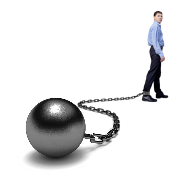 istock Man stands with a ball and chain on his ankle 95885728