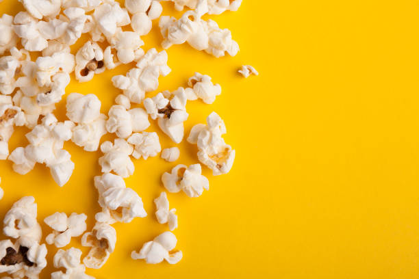 istock Slaty popcorn scattered on yellow background, top view 958869036