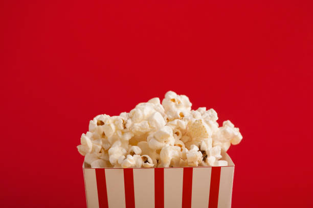 istock Bucket of popcorn on red background 958869094