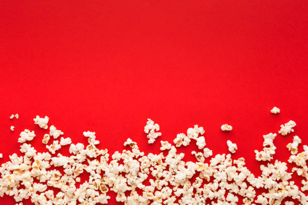 istock Slaty popcorn scattered on red background, top view 958869372