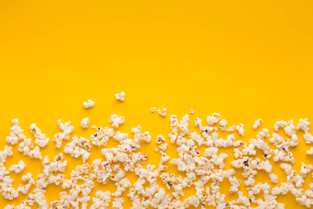 istock Slaty popcorn scattered on yellow background, top view 958869400