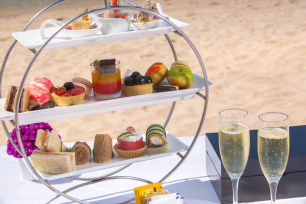 istock Afternoon tea set arrangement on beach, tea set with desserts, cookie, pastries ocean view 958871948