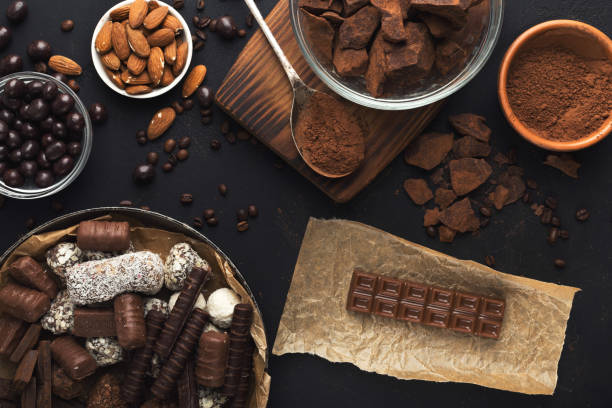 istock Top view on chocolate and nuts on black background 958874706