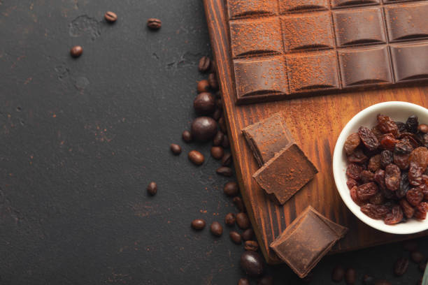 istock Crushed chocolate pieces and raisons on gray background 958875110