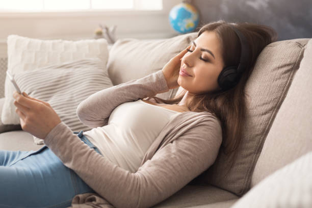 istock Young girl in headphones with mobile 958877754