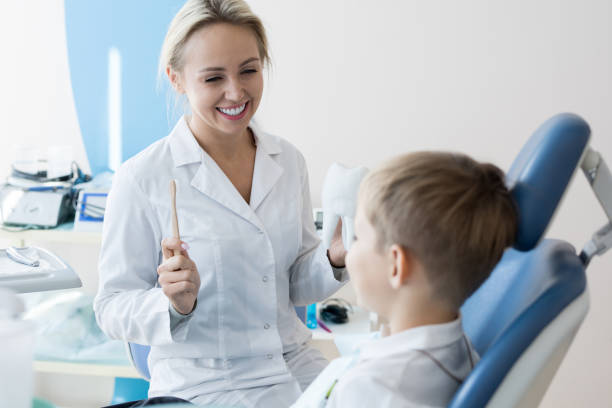 istock Smiling Dentist Explaining Dental Care to Child 958878886