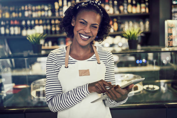 istock Young African entrepreneur standing in her cafe using a tablet 958879074