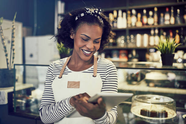 istock Young African entrepreneur standing in her cafe using a tablet 958879180