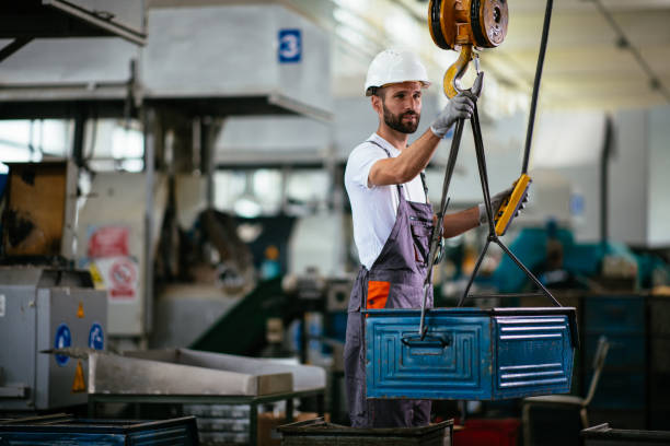 istock Young male engineer in factory using lifting beam 958882286