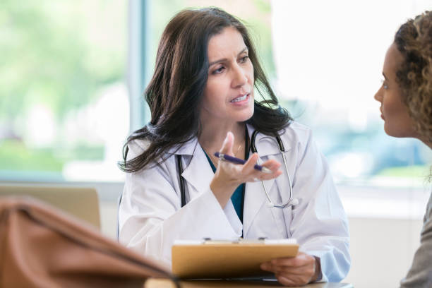 istock Serious doctor discusses diagnosis with young patient 958886654