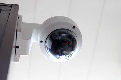 One white smaller spherical security digital camera for building surveillance