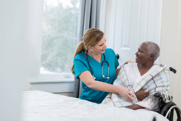 istock Nurse assists woman in nursing home 958891746