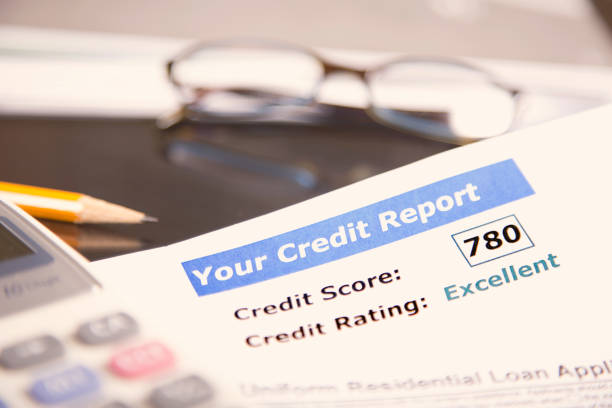 istock Credit report, score, loan documents, digital tablet, eyeglasses, and calculator on desk. 958892012