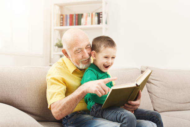 istock Senior man reading book for his grandchild 958895330