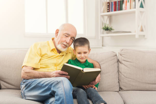istock Senior man reading book for his grandchild 958895984