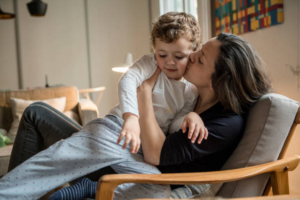 istock Playful mother kissing son 958901692