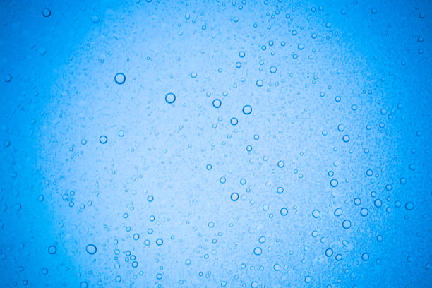 istock Rain droplets on blue glass background, Water drops on glass. 958903210