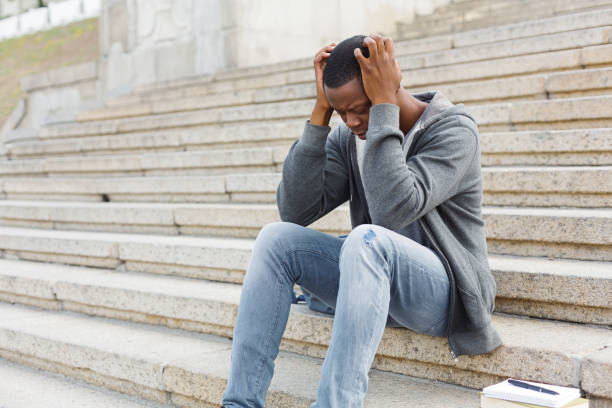 istock Stressed african-american man sitting on stairs 958908828
