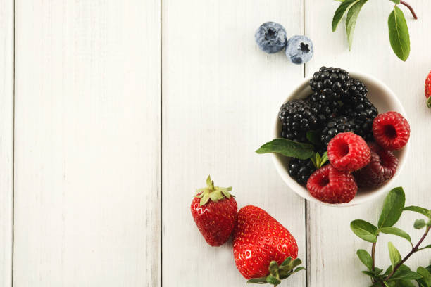 istock Mixed berries in glass bowls closeup, top view 958910292
