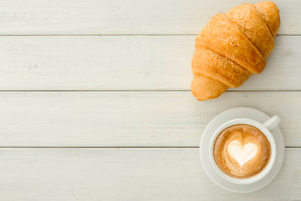istock Breakfast with coffee and croissants on white rustic table 958914626