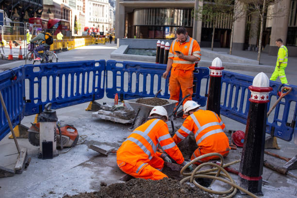 trabajadores de la construcción desenterrando una calle en londres en busca de posibles goteras de agua. - editorial land vehicle construction equipment built structure fotografías e imágenes de stock