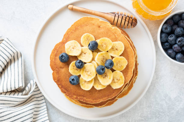 istock Corn pancakes topped with banana, blueberries and honey 958915648