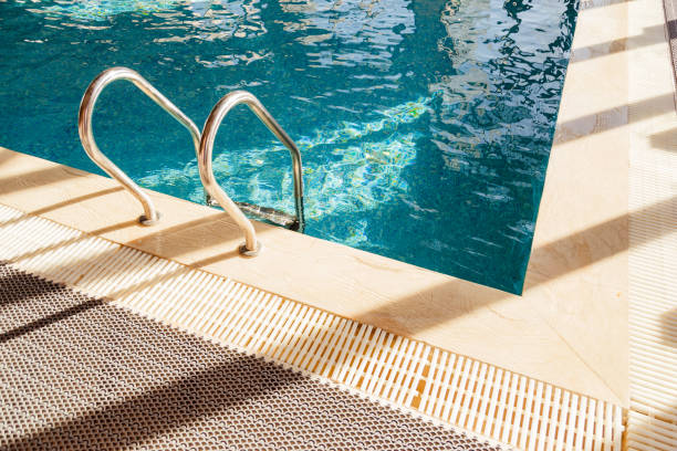 istock Grab bars ladder in the blue swimming pool 958918888