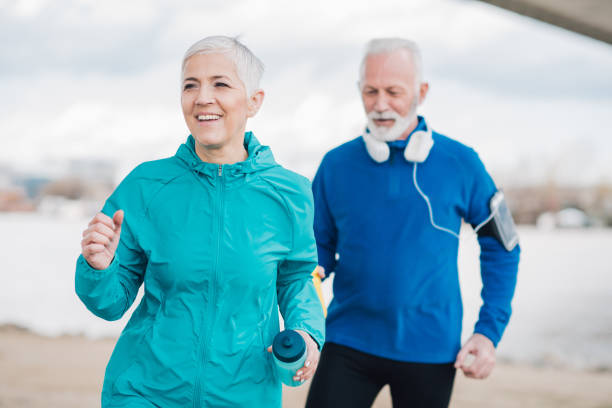istock Happy people holding water bottles while jogging 958920182