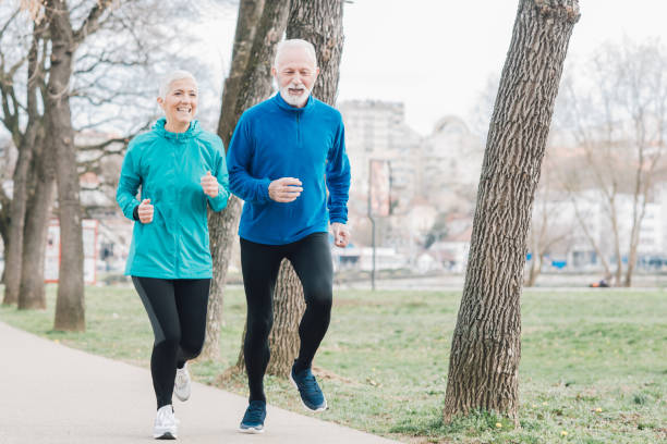 istock Senior couple exercising in public park 958920286