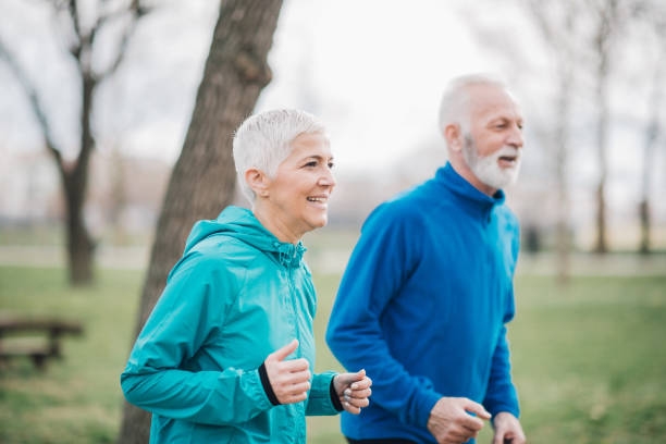 istock Senior couple jogging in park and smiling 958920316