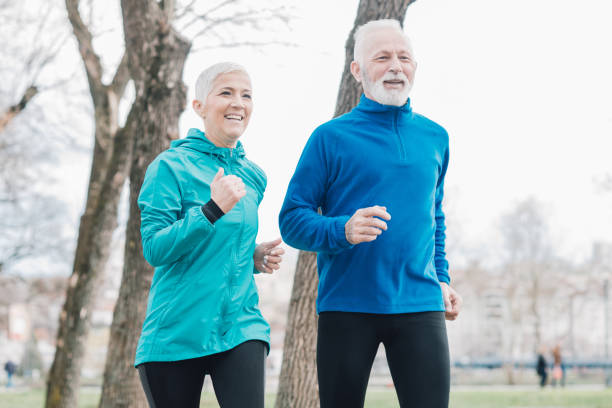 istock Happy people jogging in park 958920336