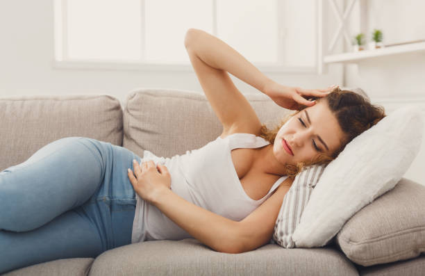 istock Sad redhead girl feeling pain lying on sofa 958920482