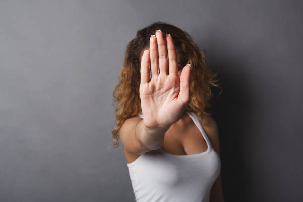 istock Young woman covering her face with palm 958923824