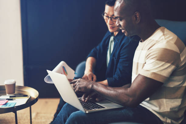 istock Two diverse office colleagues working together on a sofa 958927600