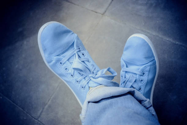 istock Feet jeans sneakers floor 958931524