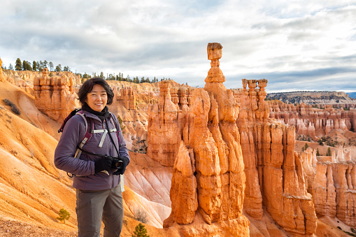 mature asian woman hiking Bryce Canyon National Park. Thor's hammer