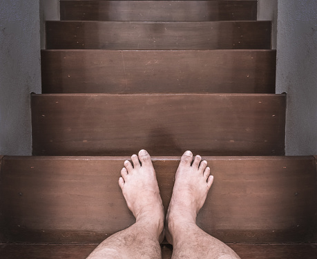 The barefoot man was walking down the stairs.