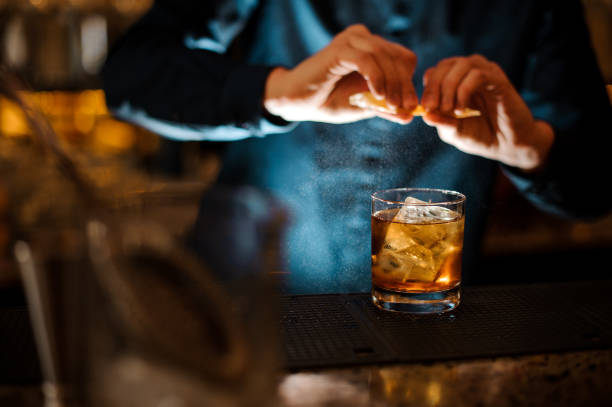 istock Brunet bartender adding a fresh orange juice to the cocktail 958940268
