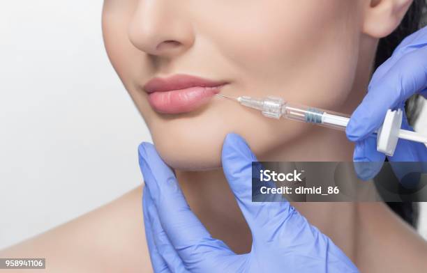 The Doctor Cosmetologist Makes Lip Augmentation Procedure Of A Beautiful Woman In A Beauty Salon Stock Photo - Download Image Now