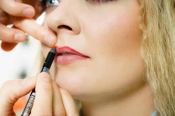 istock Applying lipstick on fashion model lips 958941882