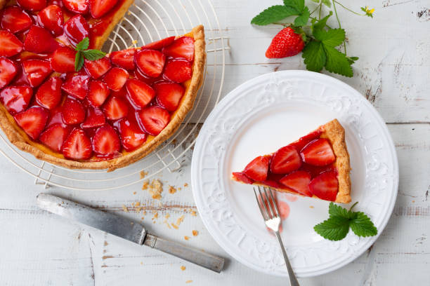 Home made delicious strawberry tart Homemade strawberry tart decorated with strawberry leaves and portion in a plate. Top view dessert pie stock pictures, royalty-free photos & images