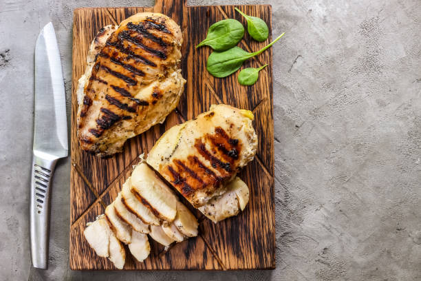 grilled chicken fillets on wooden cutting board grilled chicken fillets on wooden cutting board prep with cooked quinoa and spinach for healthy food grilled chicken breast stock pictures, royalty-free photos & images