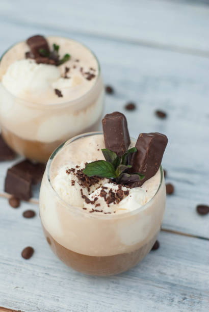 istock Iced Mocha Frappe Coffee with Whip Cream, Summer Drinking times. Coffee Beans. rustic textured Wooden Background. Mint Leaves 958961978