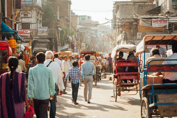 belebten straße von alt-delhi, indien - rikscha transport von personen auf einer straße in alt delhi indien stock-fotos und bilder