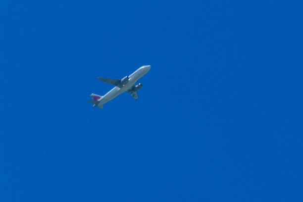 istock Airplane flying in the blue sky 958972506