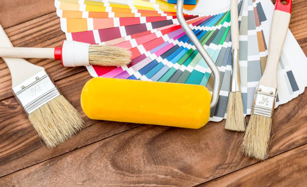 istock Paint roller and brushes with color swatches book on the table. 958977060